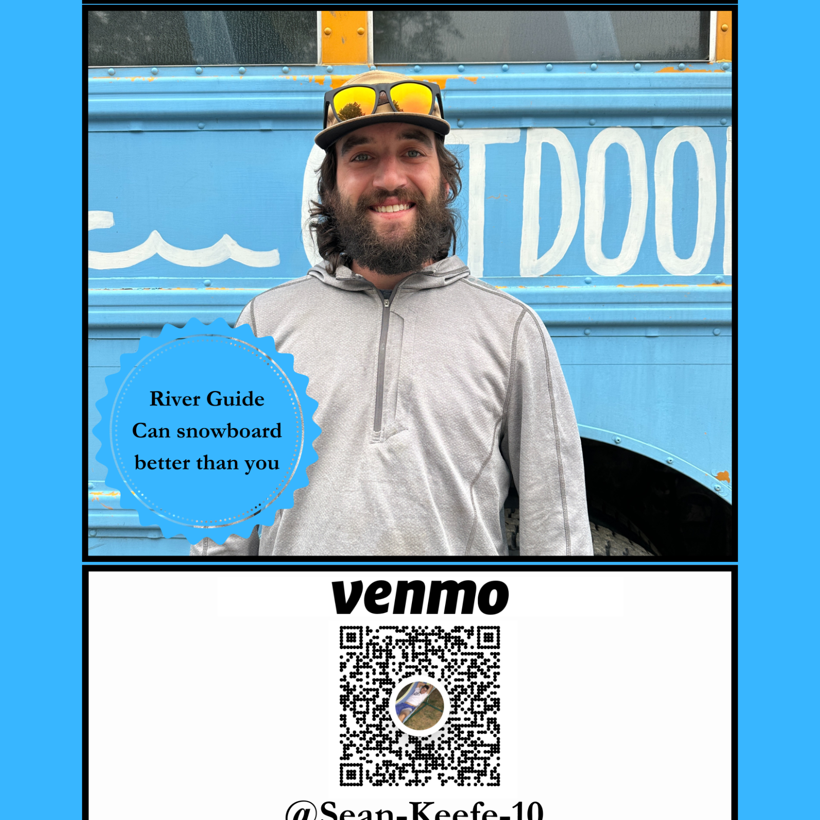 Man in hoodie standing in front of a blue bus with text, wearing sunglasses on head.